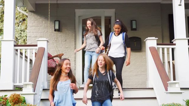 Four teen girlfriends leaving house for school