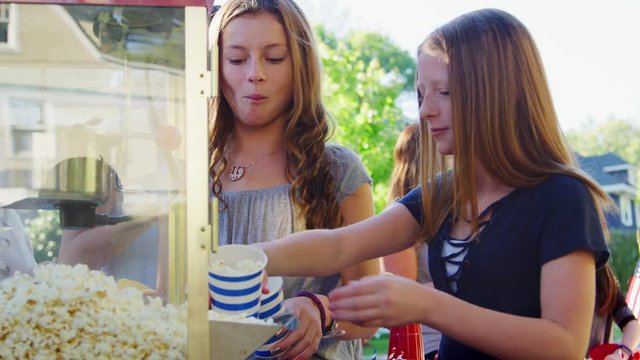 Girls serve themselves popcorn at neighbourhood block party