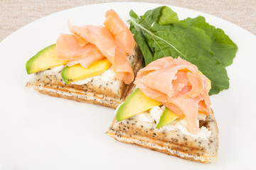 Healthy  breakfast  waffles with avocado and salmon