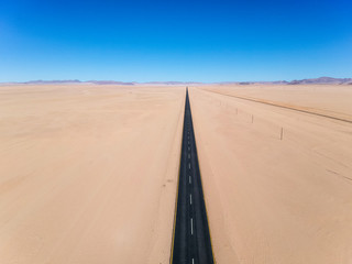 Stunning wide angle aerial drone view of the B4 desert road and a train line between L&uuml;deritz and Keetmanshoop in the Namib Naukluft Desert Park of Namibia, Africa. No curves on the road.