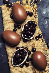 Easter composition with chocolate eggs and sweets, dark background, top view