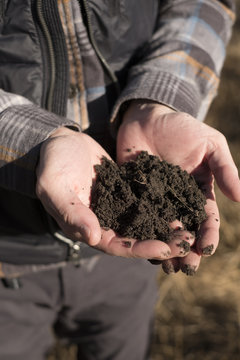 Close-up of man holding a handful of healthy soil