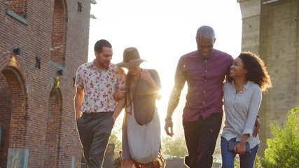 Group Of Friends Walking By Brooklyn Bridge In New York City