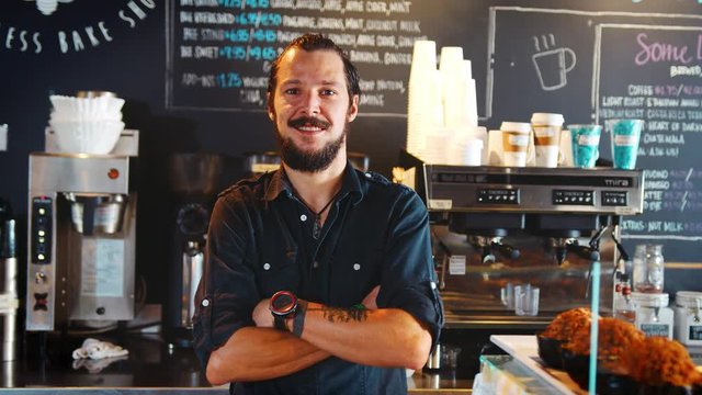 Portrait Of Male Barista Behind Counter In Coffee Shop
