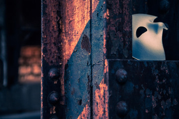Phantom of the Opera mask on a dark gritty retro vintage steel bridge