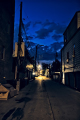 Fototapeta premium Dark city alley during sunset with dramatic sky and clouds