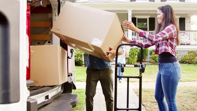 Children Helping Unload Boxes From Van On Family Moving In Day