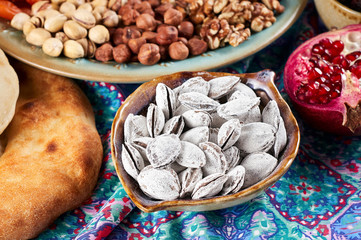 Traditional Azerbaijan sweet cuisine of holiday Nowruz: apricot bones fried with salt, assortment of nuts and dry fruits