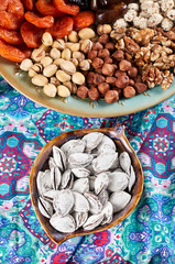 Traditional Azerbaijan sweet cuisine of holiday Nowruz: apricot bones fried with salt, assortment of nuts and dry fruits