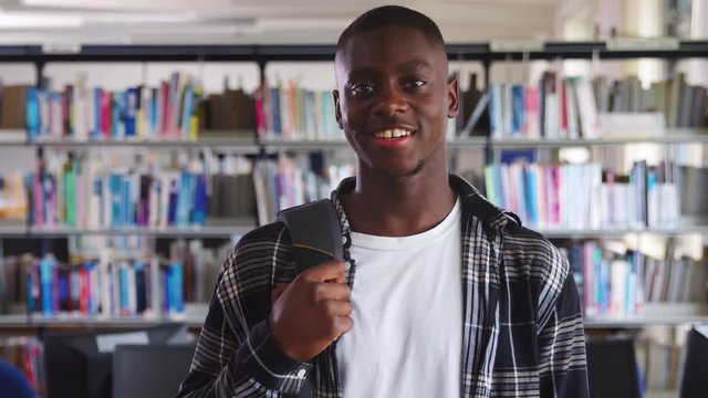 Portrait Of Male Student Standing In College Library