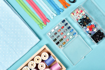 Pastel color background, Dressmaker and designer desk, Handcraft accessories, Threads roll, scissors, zip, button.