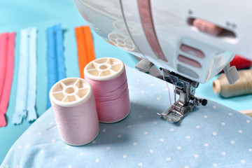 Pastel color background, Dressmaker and designer desk, Close up foot of sewing machine and handcraft accessories.