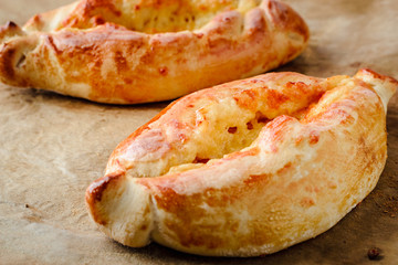 two appetizing khachapuri on parchment for baking