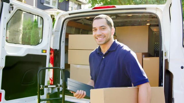 Portrait Of Courier With Digital Tablet Delivering Package