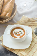 Vegetable cream soup with shrimps and croutons in white bowl close up