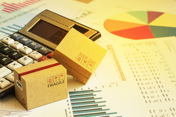 Packaging cardboard boxes with calculator and this type of financial charts include stacks of bar compare between the expansion of export business and increase the rate of goods each year.