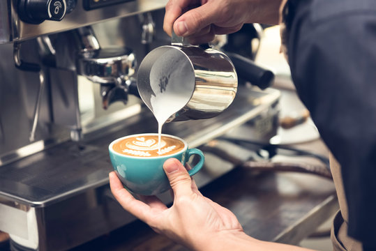 Barista making Rosetta shape latte art coffee