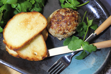 Food, lunch. Meat cutlet with toast, cilantro and parsley on a plate.