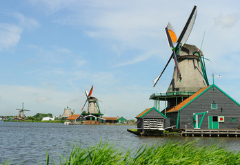 Naklejka premium Traditional dutch windmill near the canal in summer day. Netherlands