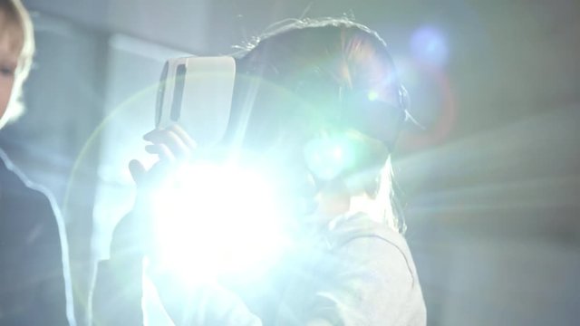 Primary school girl with two braids using virtual reality glasses as part of information technology lesson