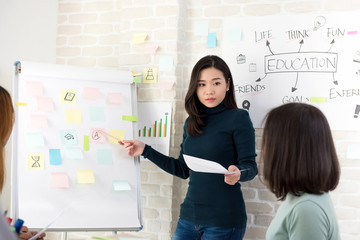 Asian woman college teacher teaching her students in classroom