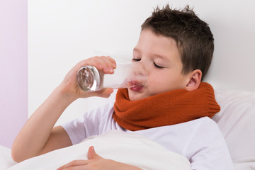the boy in the crib drinks water from the glass, the doctor's recommendations in case of illness