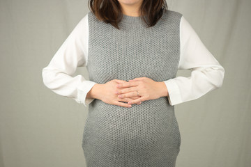 お腹をおさえた妊婦