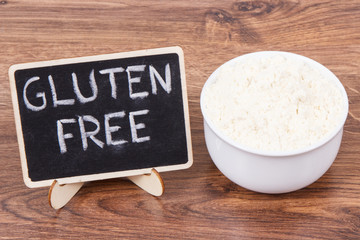 Inscription gluten free and millet flour in glass bowl, healthy food