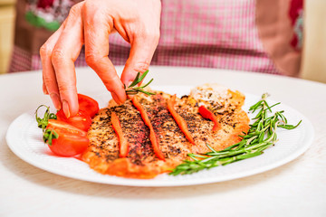 Cooking roasted fish fillet with vegetables close