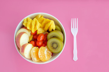 Healthy food. Fruit in the bowl. Pink background.