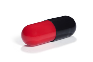 Red and black capsule with medicine on a white background