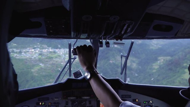 Landing aircraft at Tenzing-Hillary Airport in Lukla. Cockpit view of plane landing. The airport in Lukla is the most dangerous airport in the world. A small plane to transport hikers, tourists and