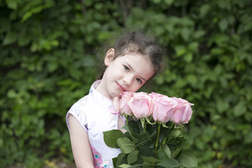 Fototapeta premium Cute toddler girl holding roses