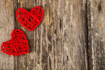 Two red hearts on an old wooden background