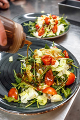 Chef pouring salad sauce