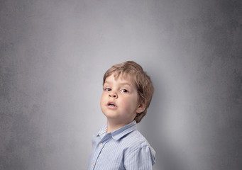 Adorable little boy in front of an empty wall