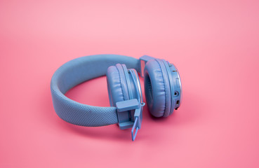 Blue headphone on light pink background,vintage or pastel concept