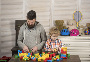 Family games concept. Family play with construction plastic blocks.