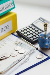 Fototapeta premium Clean insurance form, folders, piggy bank and money
