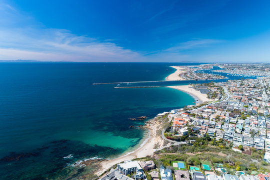 Aerial view of coastal Newport Beach in Orange County, California, USA with coast, sand and blue skies.