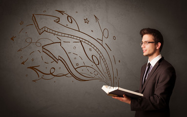 Young man holding book with arrows