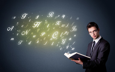 Young man holding book with letters