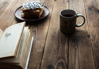a cup of tea and a pile of wafers and book