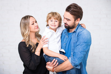 happy family portrait - couple and little son over white