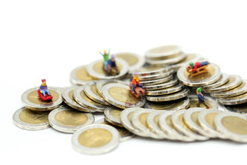 Miniature people : Child  having fun to play slider on coins.