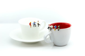 Miniatures people : sitting on a cup of coffee,relax and business concept.