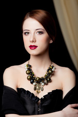 Naklejka premium Portrait of a beautiful style redhead girl with necklace
