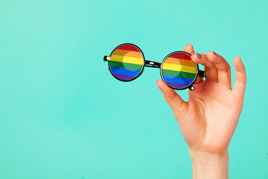 Female Hand Holding Glasses With Rainbow Flag