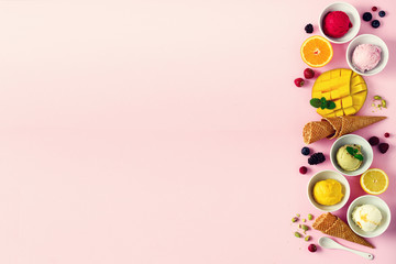 Top view red, pink, yellow, green, white ice cream balls in bowls, waffle cones, berries, orange, mango, pistachio, pink shabby chic background. Ice-cream colorful collection, flat lay, summer concept © jchizhe