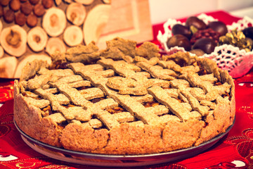 Vegan homemade apple and cinnamon pie with a white bowl and chopping board behind.